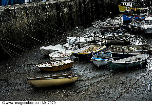 High angle view of fishing boats moored in harbour at low tide.