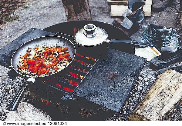 High angle view of food in cooking pan on fire pit at campsite