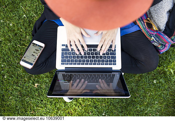 High angle view of freelancer using laptop at park