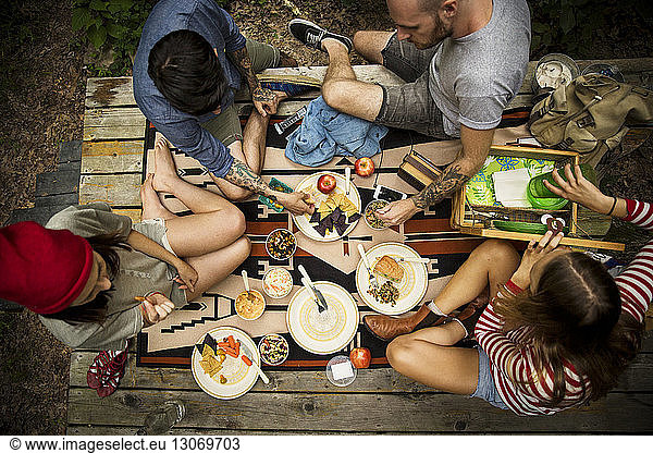 High angle view of friends having food while sitting on porch