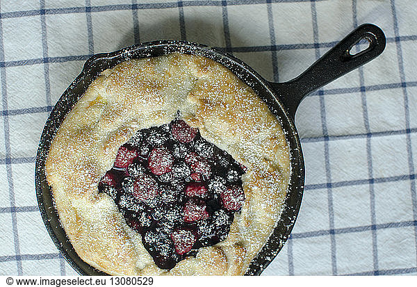 High angle view of galette in cooking pan on napkin