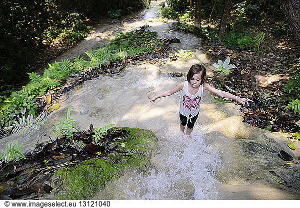 High angle view of girl with arms outstretched standing at Bua Thong Waterfalls