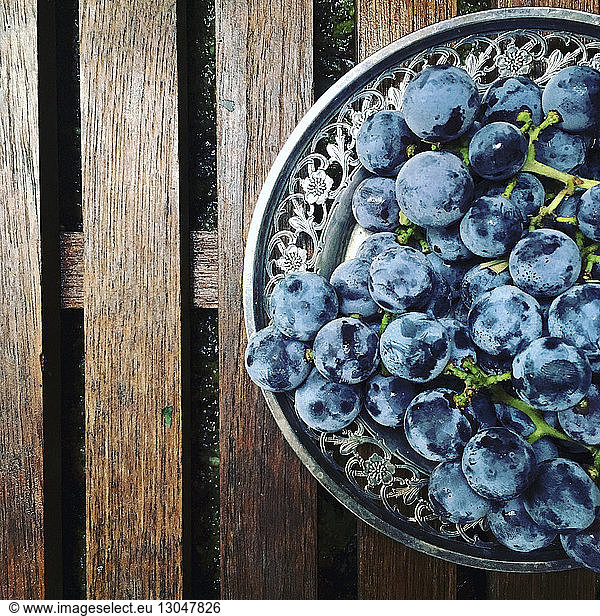High angle view of grapes in plate on jetty