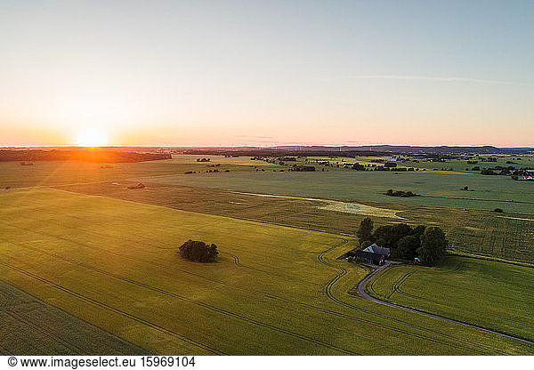 High angle view of grassy field against clear sky during sunset