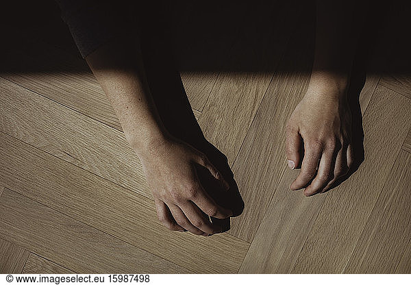 High angle view of hands on hardwood floor