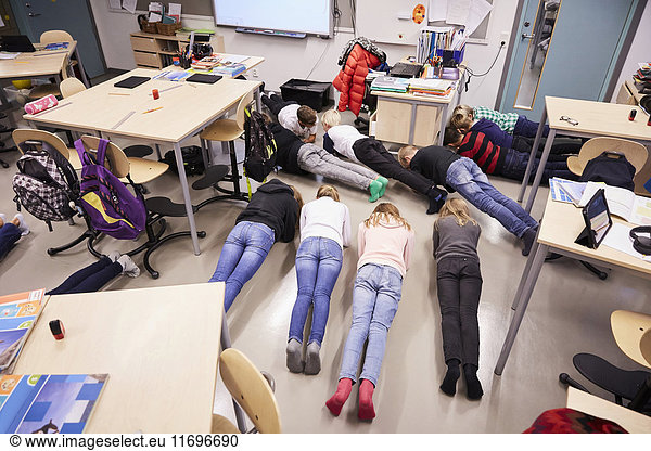 High angle view of junior high students in plank position at classroom