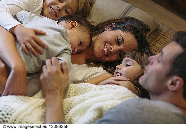 High angle view of kids with parents sleeping on carpet at home