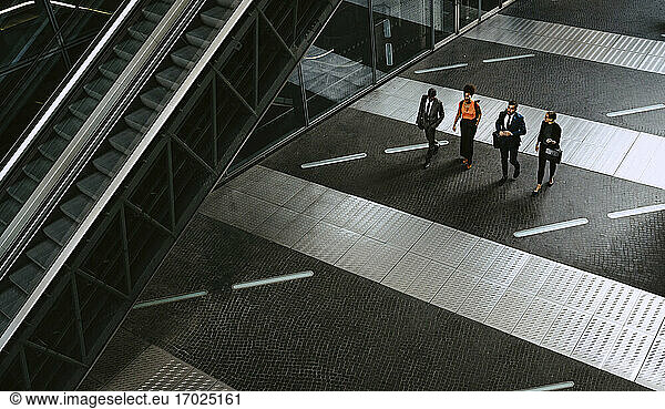 High angle view of male entrepreneurs discussing with female colleagues on walkway