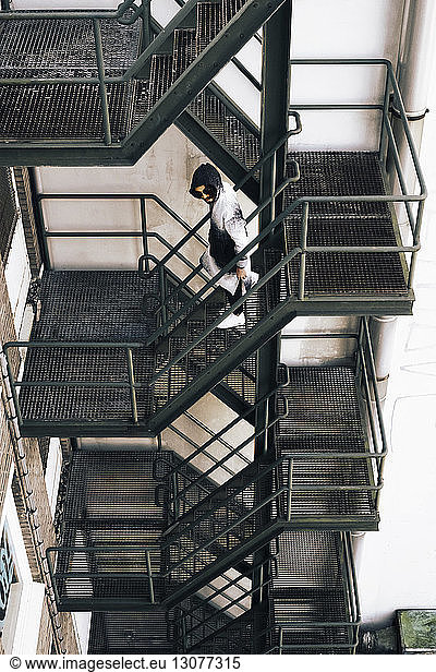 High angle view of man moving down on fire escape