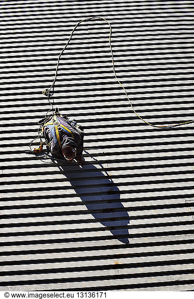 High angle view of manual worker working welding at construction site