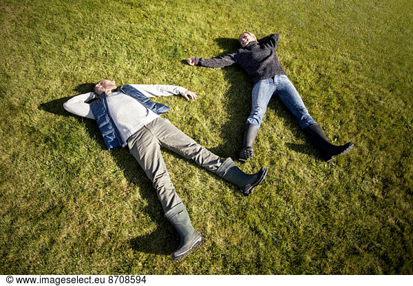 High angle view of mature couple lying on grass