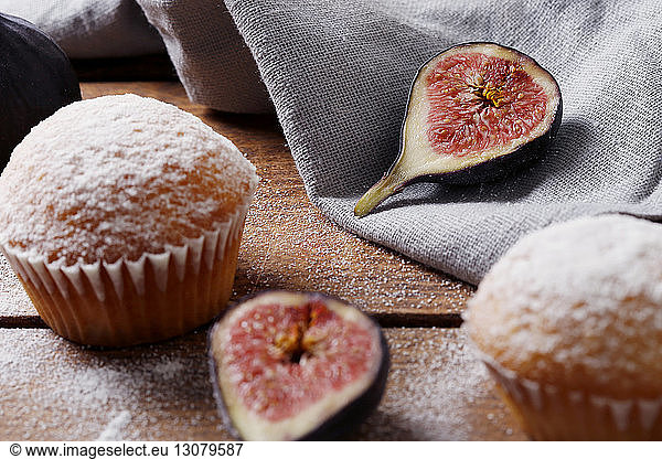 High angle view of muffins with figs and napkin on wooden table