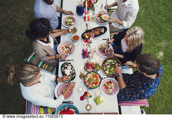 High angle view of multi-ethnic friends enjoying meal at garden party