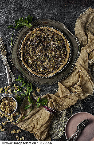 High angle view of mushroom tart and cashew nuts on table
