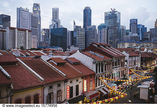 High angle view of old shophouses of Chinatown and the modern skyscrapers of Singapore at dusk.