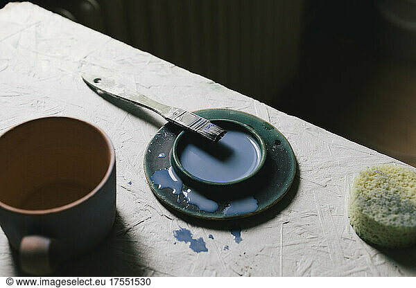 High angle view of paint and paintbrush at table