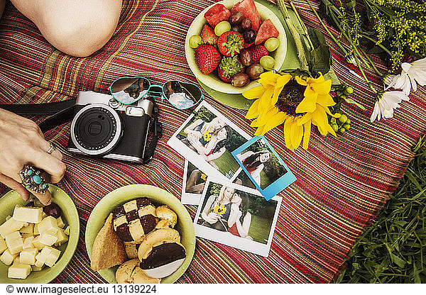 High angle view of photographs and food on fabric at field