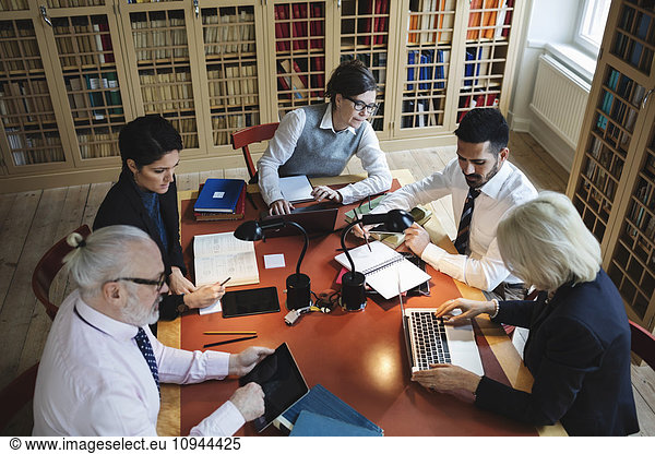 High angle view of professionals working at table in law library