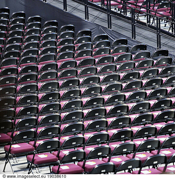 High angle view of rows of empty folding chairs in indoor auditorium.