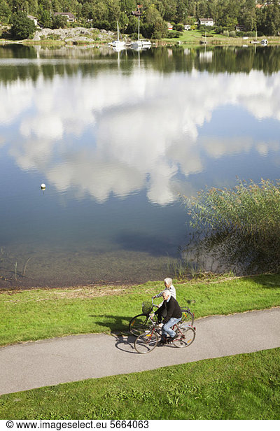 High angle view of senior couple cycling near lake