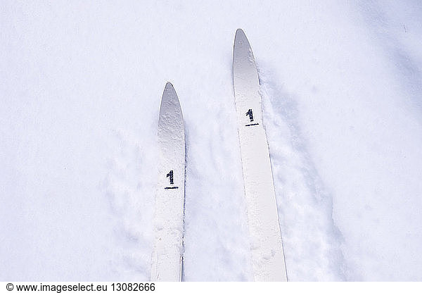 High angle view of skis with number 1 on snow covered field