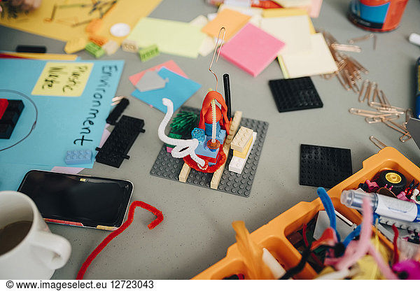 High angle view of toy amidst stationery on table at creative office