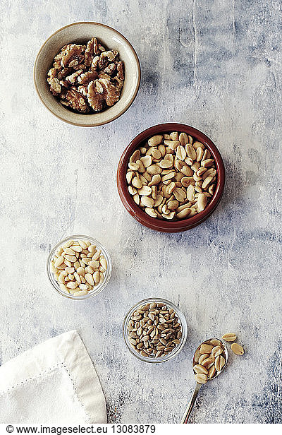 High angle view of various nuts in bowls on table