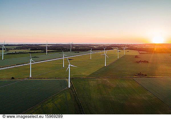 High angle view of windmills on grassy field against clear sky