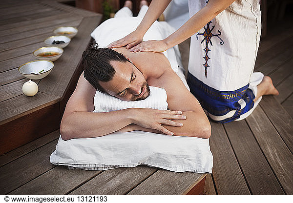 High angle view of woman massaging man at beauty spa
