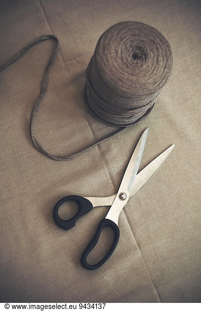 High angle view of wool spool and scissors on table