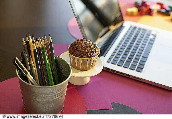 High angle view of writing instrument  cake and laptop on table at home