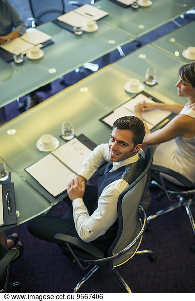 High angle view of young businessman sitting at conference table