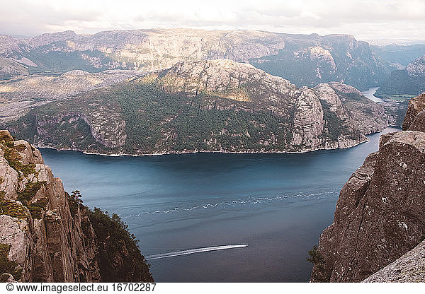 High view of boat cruising through fjords in Norway