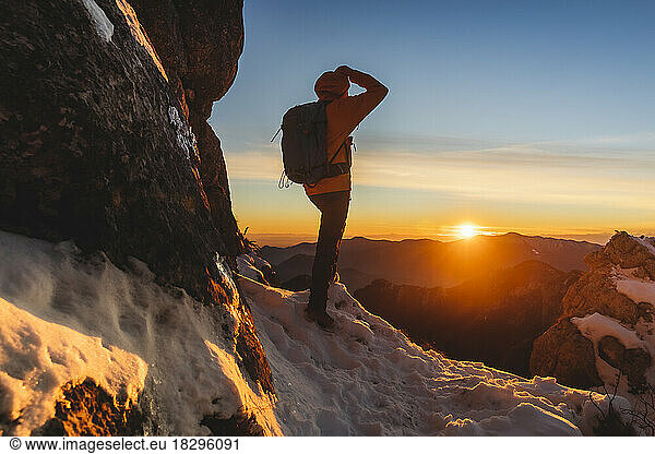 Hiker enjoying sunset standing on mountain