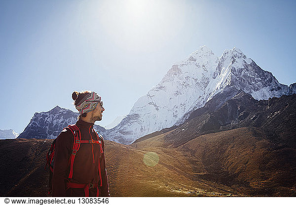 Hiker in warm clothing standing on mountain against clear sky at Sagarmatha National Park