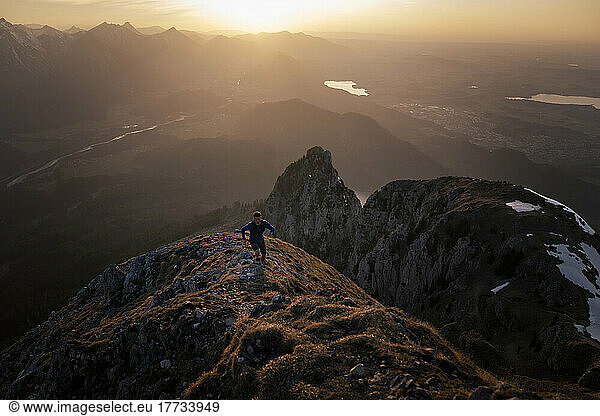Hiker moving up on mountain peak at sunset