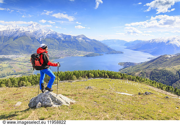 Hiker on green meadows admires Lake Como surrounded by woods  Montemezzo  Alpe Zocca  Lombardy  Italian Lakes  Italy  Europe