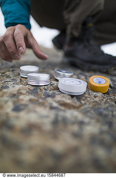 hiker reaches for a canister of survival supplies