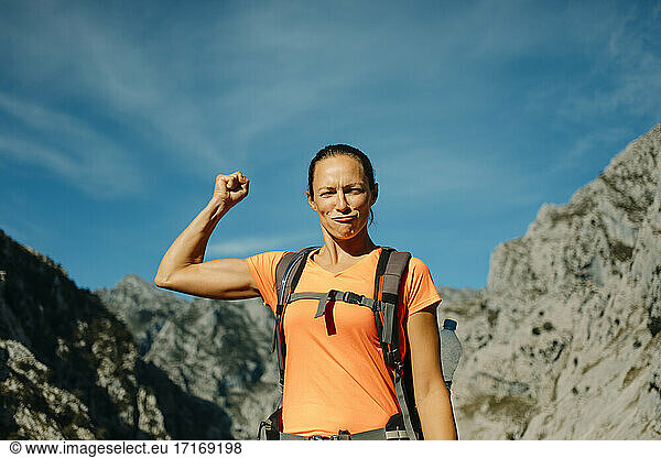 Hiker showing biceps while standing against sky at Cares Trail in Picos De Europe National Park  Asturias  Spain