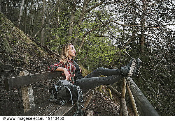 Hiker sitting on bench in forest