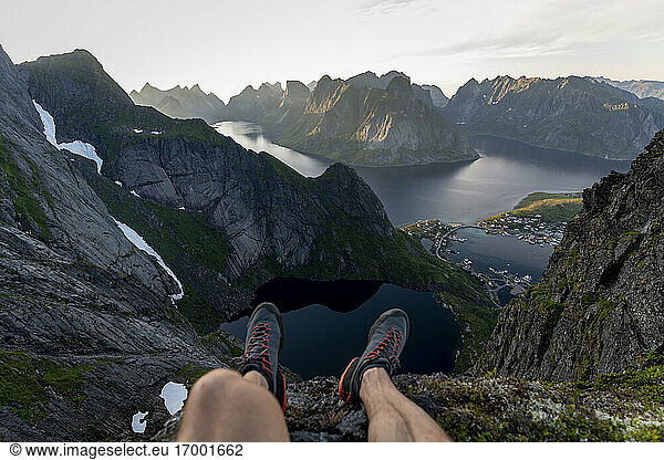 Hiker sitting on mountain at Reinebringen  Lofoten  Norway