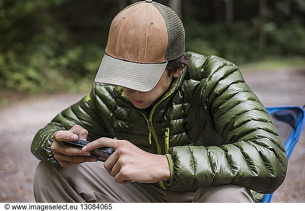 Hiker using phone while resting at camp site