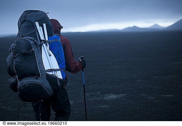 Hiker waling across highlands in central Iceland