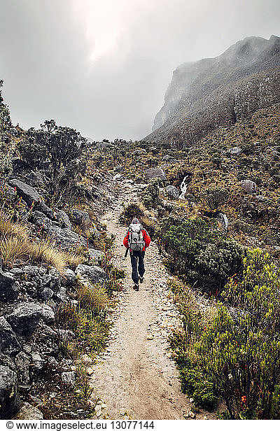 Hiker walking along mountain trail