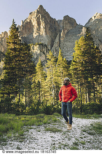 Hiker walking in front of Dolomites  Italy