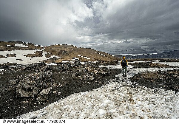 Hikers in snow-covered volcanic landscape with volcanic sand and petrified lava  crater of Askja volcano  Icelandic highlands  Iceland  Europe