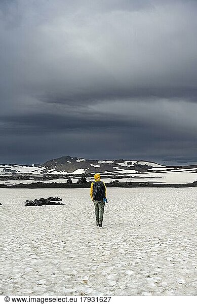 Hikers in snow-covered volcanic landscape with volcanic sand and petrified lava  crater of Askja volcano  Icelandic highlands  Iceland  Europe