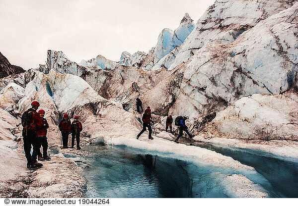 Hikers scrambling around on a glacier.