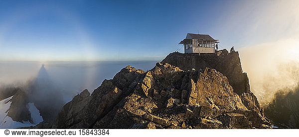 Hikers stand at sunrise outside Three Fingers Lookout  North Cascades