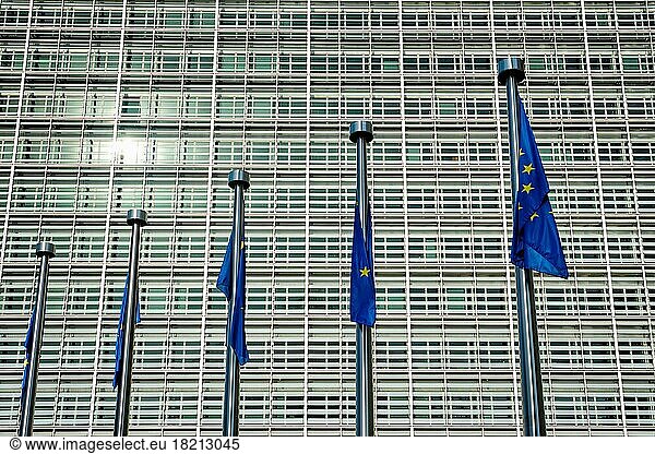 Hilflos hängende EU-Fahnen der Europäischen Union mit dem Gebäude der Europäischen Kommission im Hintergrund. Brussles  Belgien  Europa